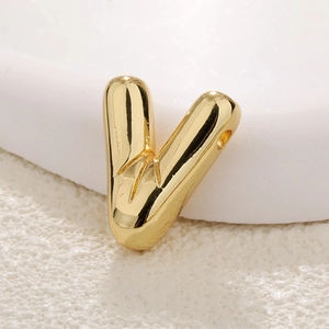 Close-up of polished gold-plated letter V bubble pendant showing smooth texture and side hole