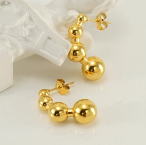 Detailed view of graduated golden metallic beads on high-quality titanium steel earrings
