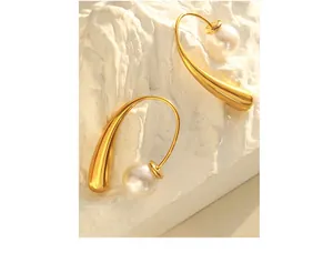 Macro view of teardrop earrings in 18K gold plated steel with white round pearls