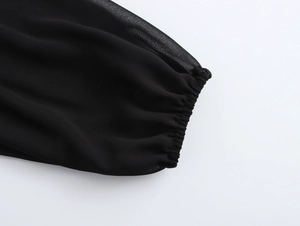 Détail de manches élégantes en mousseline noire avec poignets élastiques à volants fins