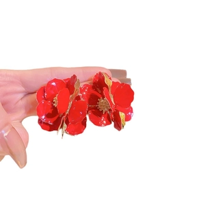 Elegant red flower stud earrings with gold petal trim on white background