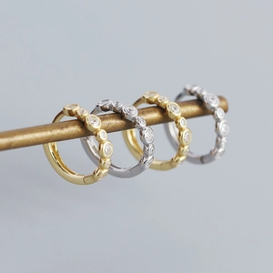 Row of gold and silver S925 sterling silver hoop earrings with clear cubic zirconia stones