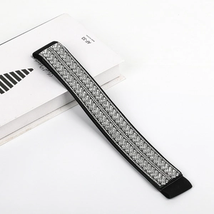 Close-up of sparkling rhinestone geometric patterns on a black elastic waist belt