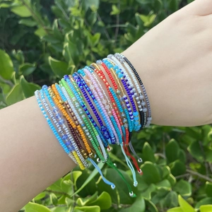Detail of layered bohemian seed bead bracelets in vibrant blue, yellow and red colors