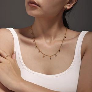 18K gold plated thin necklace with natural stones and matching earrings on a female model