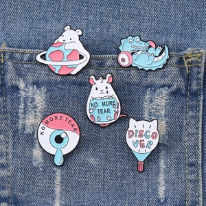Cute enamel animal pins featuring polar bear and crocodile on blue denim pocket fabric