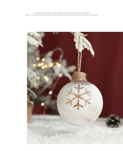 Close-up of white snowflake hollow Christmas ball hanging on snowy branch decoration