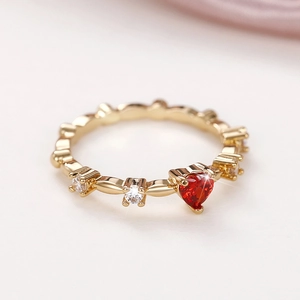 Detail of red heart-shaped gemstone ring with gold plating and white zircon accents