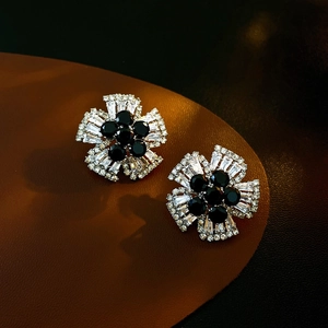 Vue détaillée des boucles d'oreilles fleurs avec cristaux de zircone noirs et blancs polis