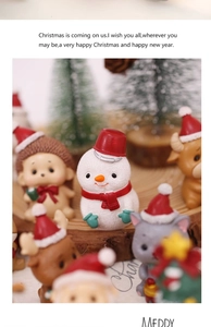 Close-up of resin Christmas miniatures like snowmen and reindeer on a wooden base