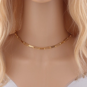 Elegant gold-plated rectangular link chain necklace worn by a model on a solid background