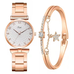 Detail of rose gold watch and star pendant bracelet set with crystal accents