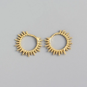 Detail shot of gold hoop earrings with beaded sunray design and polished metal finish
