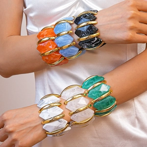 Gros plan de bracelets géométriques en acrylique avec détails dorés sur le poignet