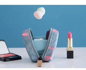 Détail de la trousse de maquillage bleue à motifs flamants roses avec rouge à lèvres