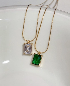 Detail of square emerald and clear zircon pendant necklaces in 18k gold plated finish