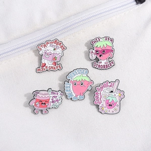5-piece strawberry enamel pin set with funny puns on white fabric background