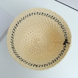 Detailed top view showing the intricate beige straw weave and black wavy trim of the bucket hat