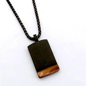 Macro view of black square pendant necklace with tiger eye stone and arrow engraving