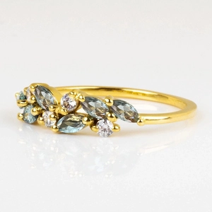 Minimalist gold leaf ring featuring marquise-cut light blue gemstones and round zircons