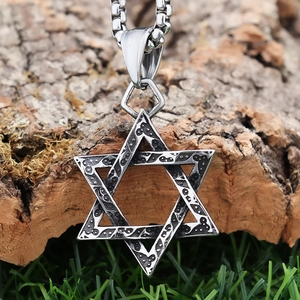 Macro detail of vintage silver hexagram pendant with textured finish on a box chain