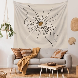 Bohemian tapestry featuring minimalist sun and moon line art over a modern sofa