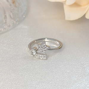 Elegant silver open ring with star-shaped micro-set zircon design on silk background