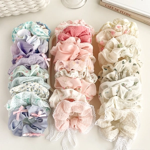 Flat lay of assorted floral lace scrunchies in pastel colors with bow ribbon details