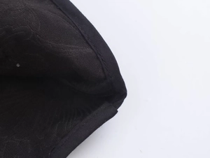 Close-up of black twill fabric jacket featuring precision stitching and high-quality texture