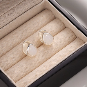Elegant cat eye stone teardrop earrings in silver setting displayed in a jewelry box