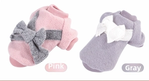 Detail of soft coral fleece pet sweaters in pink and grey with large back bows