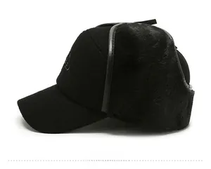 Side view of a winter trapper hat with black faux fur earflaps and embroidery detail