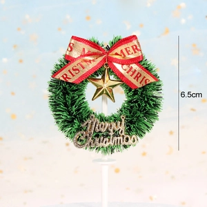Detailed view of a 6.5cm Christmas wreath cake topper with golden star and red bow