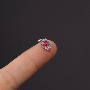 Nahaufnahme von rosa Zirkon-Ohrringen aus Edelstahl auf einer Fingerspitze präsentiert