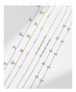 Detailed close-up of S925 silver and gold bracelets with pavé star and flower charms