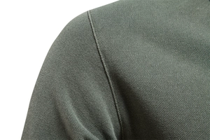 Close-up of shoulder seam and breathable cotton piqué fabric texture on army green polo shirt