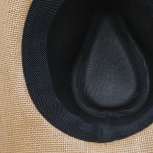 Detailed close-up of straw sun hat interior with black sweatband and reinforced lining