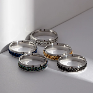 Macro shot of 5 rotating chain rings in silver, blue, gold, rainbow, and black steel