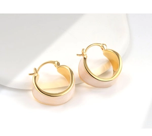 Macro detail of French style enamel huggie earrings with gold plating on stone base