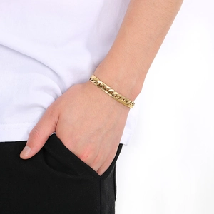 Close-up of golden Cuban link chain bracelet on wrist with polished metallic shine