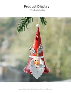 Detail of red Santa iron bell with embossed white beard hanging on pine tree branches