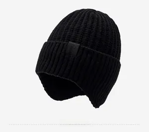 Détail du bonnet en tricot noir avec doublure en polaire et rabats pour les oreilles