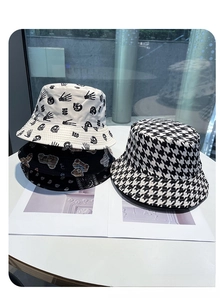 Detail shot of various patterned bucket hats including skull, plaid, and bear prints