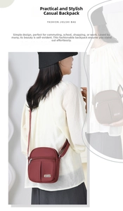 Close-up of burgundy nylon crossbody bag with multi-zipper pockets and adjustable strap