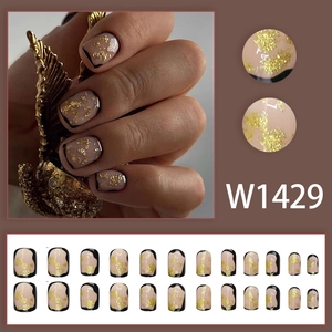 Golden luxury press-on nails with nude pink base, gold foil sequins and black french tips