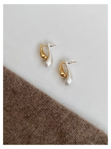 Close-up of two-tone teardrop earrings with gold and silver polished finish