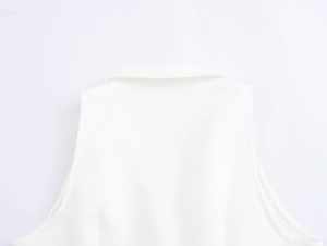 Detail of white sleeveless vest collar and shoulder area with smooth woven fabric texture