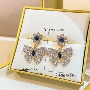 Detail of crystal butterfly bow earrings with size and weight specs in a gift box