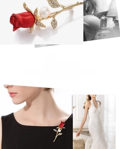Macro shot of rose brooch with red flower, pearl detail, and gold leaves set with crystals