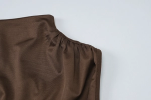Detailansicht der kaffeebraunen Strickware mit gerafftem Stoff und feinen Schulternähten